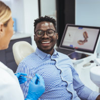 Man grinning while listening to his dentist